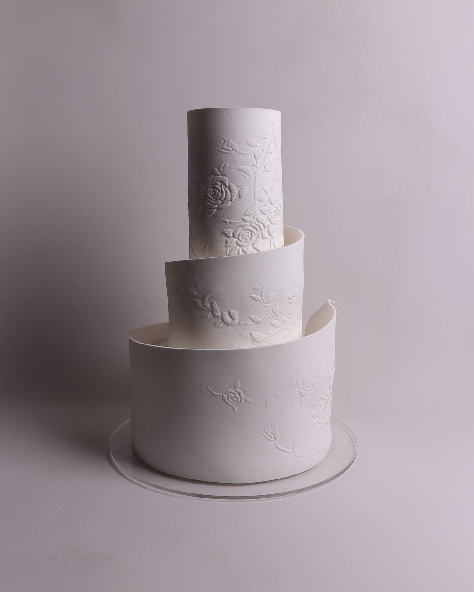 White embossed wedding cake on a plain background