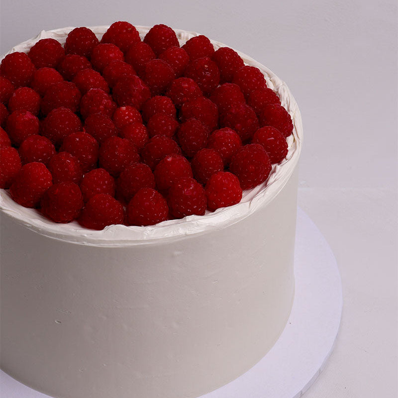 Cake with fresh organic raspberries on a white background