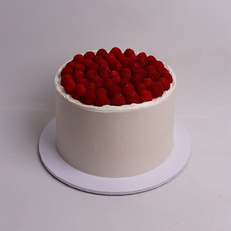 White cake with red berries on a white background